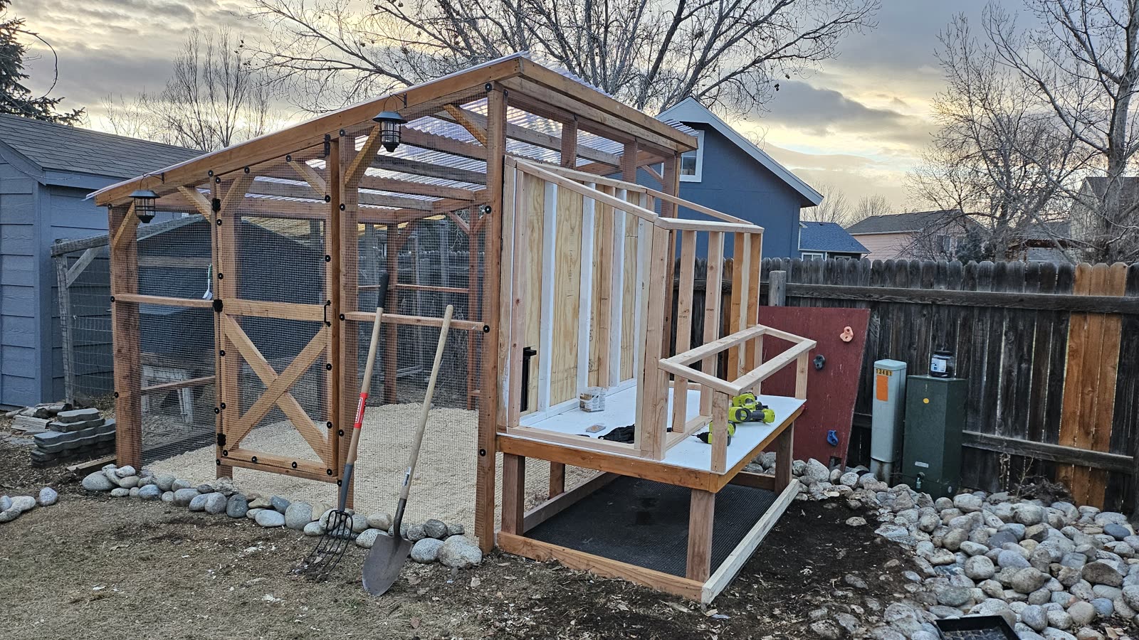The hen house framed and standing on its legs alongside the run.