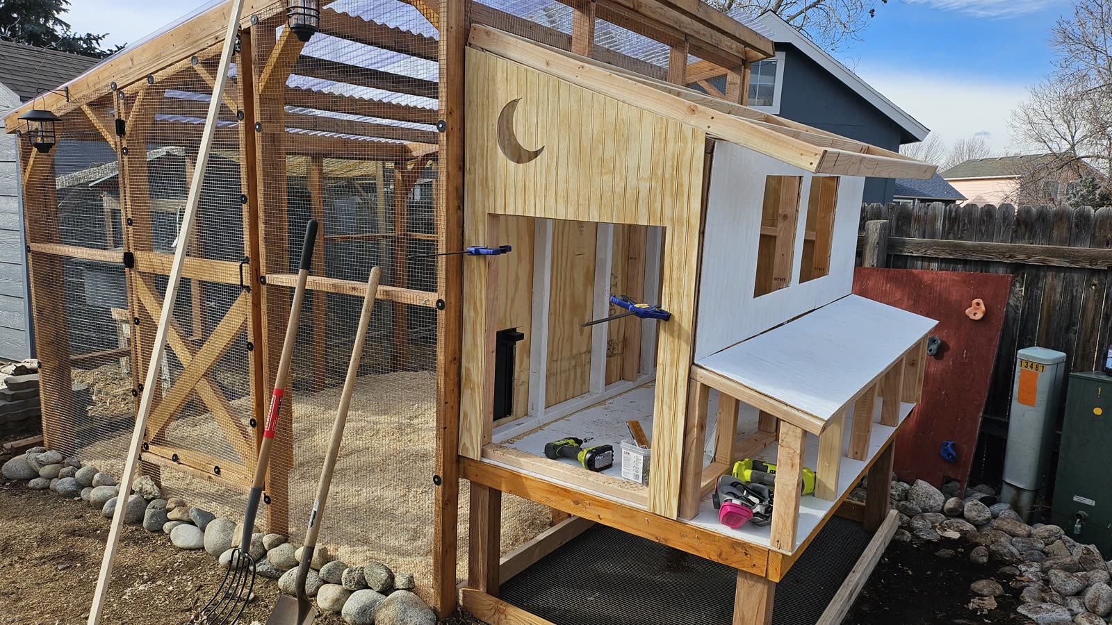 The crescent moon cut into the upper wall, with the nesting box lid propped open.